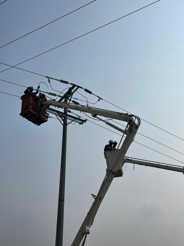 Hadaleen technicians in bucket lifts maintaining an overhead line and the insulators on a distribution pole